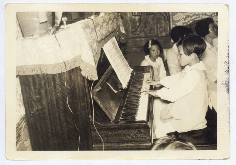A photo of Unsuk Chin as a child, at the piano